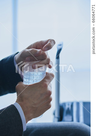 businessman drinking bottled water at the airport 66064771