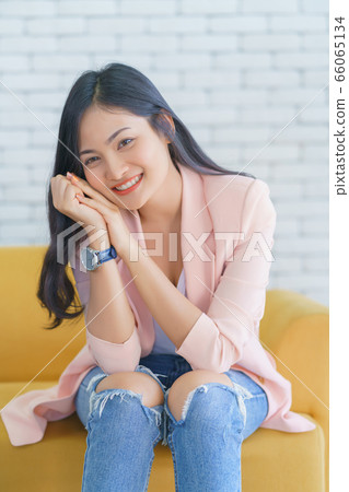 Asian woman smile relaxing sitting on sofa at living room, Lifestyle relax concept. Asian woman smile relaxing sitting on sofa at living room, Lifestyle relax concept. 66065134