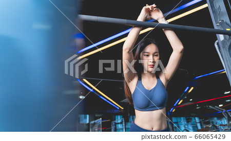 Asian Women lean on barbell machines to rest during exercise. She's holding her hand at bar with exhaustion and being alone at the gym sport and healthy concept 66065429
