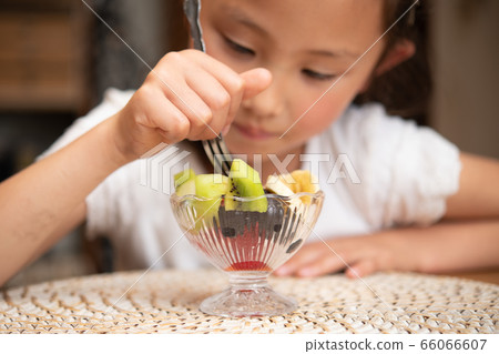 Girl eating cut fruit Girl eating cut fruit 66066607