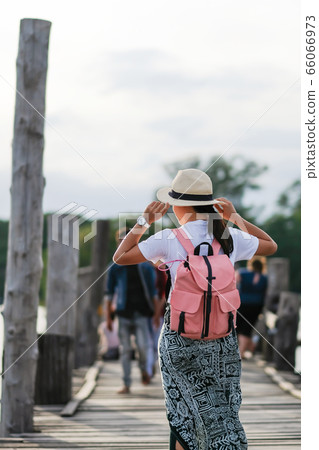 Young woman walking in U bein bridge at sunset, Young woman walking in U bein bridge at sunset, 66066973