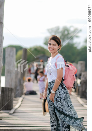 Young woman walking in U bein bridge at sunset, Young woman walking in U bein bridge at sunset, 66066974