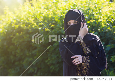 Beautiful muslim woman on a background of green Beautiful muslim woman on a background of green 66067044