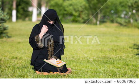Islamic woman prayer in a city park. Islamic woman prayer in a city park. 66067066
