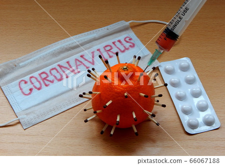 3d model of a coronavirus made of tangerine and matches, medical protective mask with an inscription, a syringe with medicine, tablets on the table. The concept of treatment of the virus. 3d model of a coronavirus made of tangerine and matches, medical protective mask with an inscription, a syringe with medicine, tablets on the table. The concept of treatment of the virus. 66067188