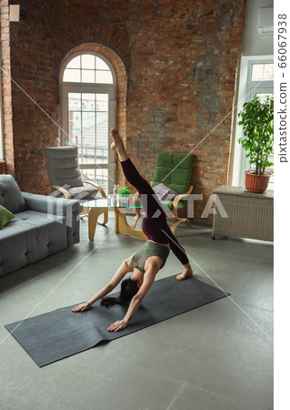 Sporty young woman practicing yoga at home 66067938