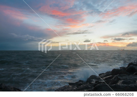Dramatic splashing ocean wave in the evening with Dramatic splashing ocean wave in the evening with 66068208