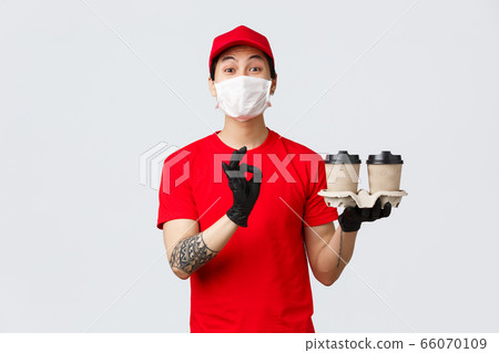 Your order is safe with our couriers. Charismatic delivery guy in red uniform and medical mask, gloves, holding drinks, bring order to client doorstep, contactless delivery, show okay, delicious sign Your order is safe with our couriers. Charismatic delivery guy in red uniform and medical mask, gloves, holding drinks, bring order to client doorstep, contactless delivery, show okay, delicious sign 66070109