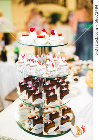 Delicious and tasty dessert table with cupcakes and shots at reception closeup 66072494