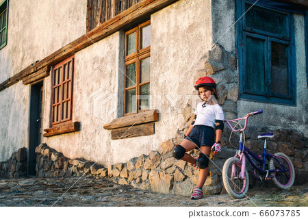 Little girl resting after a bike ride Little girl resting after a bike ride 66073785
