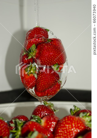 Ripe strawberries in a glass under a stream of water Ripe strawberries in a glass under a stream of water 66073940