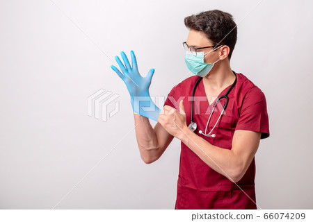 Young volunteer puts surgical gloves. Young volunteer puts surgical gloves. 66074209