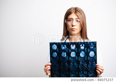 A young doctor examines an MRI image of a patient 66075237
