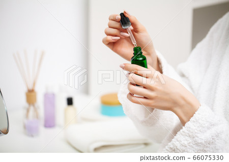 A woman uses a moisturizer to take care of her skin 66075330