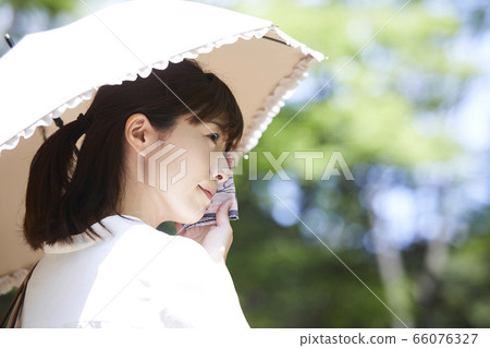 A young woman holding a parasol A young woman holding a parasol 66076327