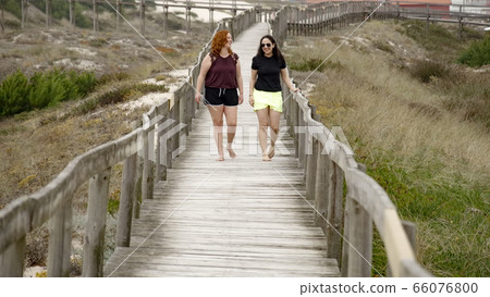 Walking on a pier over the sandy beaches Walking on a pier over the sandy beaches 66076800