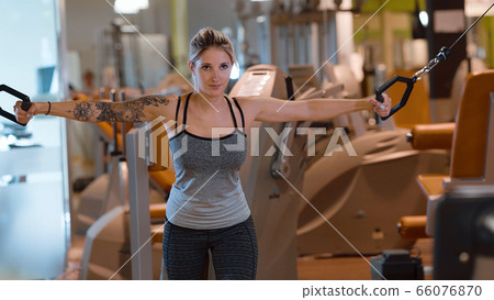 Sporty and sexy girl does exercises at a gym for fitness 66076870