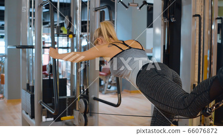 Girl at a gym doing sports at a fitness studio Girl at a gym doing sports at a fitness studio 66076872