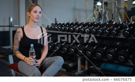 Fitness Center - young girl refreshes from sports at a gym 66076875