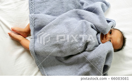 Cute happy baby new born lying on a blue knitted Cute happy baby new born lying on a blue knitted 66083081