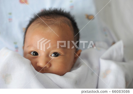 Adorable baby boy in bedroom. Newborn child Adorable baby boy in bedroom. Newborn child 66083086