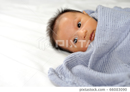 Cute happy baby new born lying on a blue knitted Cute happy baby new born lying on a blue knitted 66083090