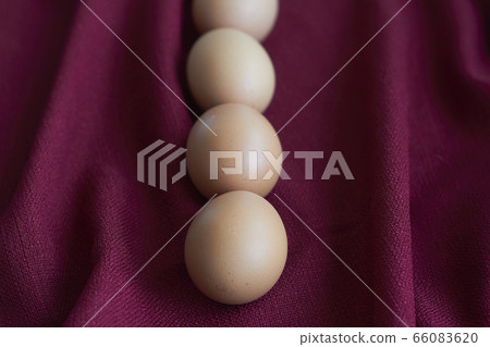Natural eggs on red tablecloth, several brown 66083620