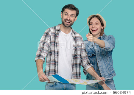 Man with map girl pointing hand forward. 66084974