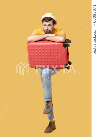 Sad bearded man in a hat with a suitcase Sad bearded man in a hat with a suitcase 66085071