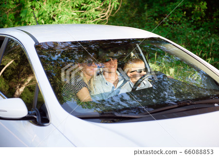 Unsafe driving. A small child sits in her father s 66088853