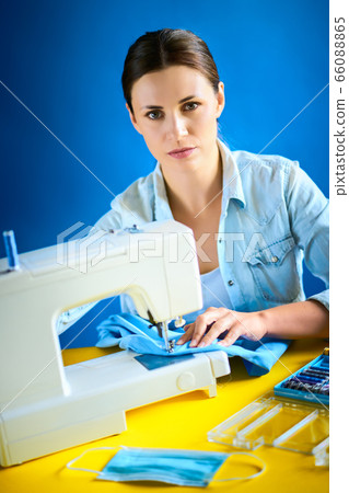 woman sews masks on the machine during quarantine 66088865