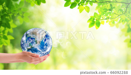 Ecology and Environment Concept : Hand holding blue planet earth with green natural in background. 66092288
