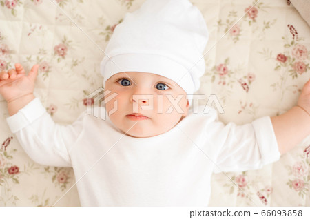 Portrait of a crawling baby on the bed in her room Portrait of a crawling baby on the bed in her room 66093858