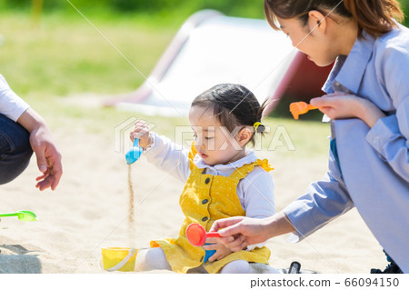 Kids and family playing with sand in park 66094150