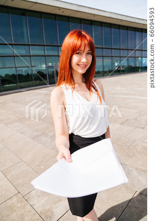 Young redhead business woman in formal outside Young redhead business woman in formal outside 66094593