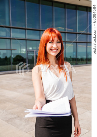 Young redhead business woman in formal outside Young redhead business woman in formal outside 66094594