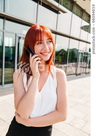 Young woman talking on mobile phone near building Young woman talking on mobile phone near building 66094659