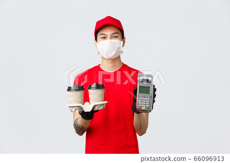 Contactless delivery, safe purchase, shopping during coronavirus concept. Smiling nice courier in medical mask and gloves, employee in fast-food deliver showing POS terminal and bring coffee customer 66096913