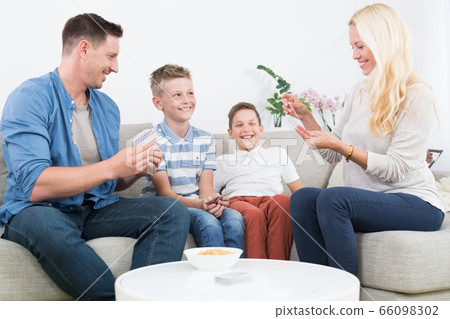 Happy young family playing card game at home. Happy young family playing card game at home. 66098302