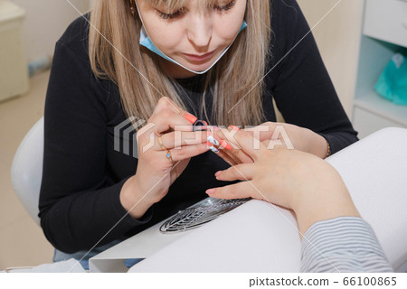 Manicuring nails - application of base coat. Selective focus, high key 66100865