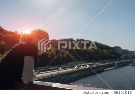 female tourist stay on bridge and look on river 66101018