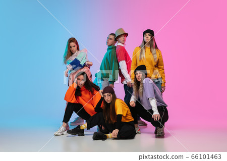 Group of dancers, boys and girls dancing hip-hop in stylish clothes on gradient studio background in neon light. Group of dancers, boys and girls dancing hip-hop in stylish clothes on gradient studio background in neon light. 66101463