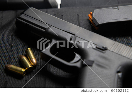 Handgun with bullets on bullet proof vest texture 66102112