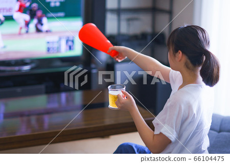 Image of a young woman watching sports at home on TV [Professional baseball video distribution service] 66104475