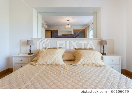 Beautiful modern bedroom with a large mirror on the wall. European hotel design. Close-up. Beautiful modern bedroom with a large mirror on the wall. European hotel design. Close-up. 66106079