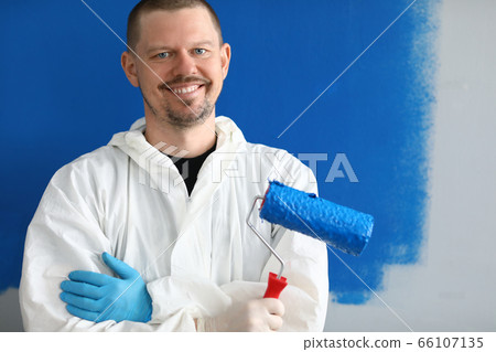 Male painter in uniform with roller in his hand Male painter in uniform with roller in his hand 66107135