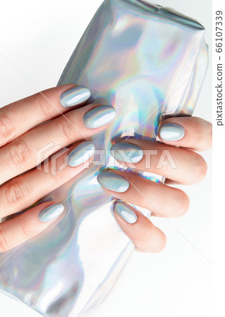 Young adult woman's hands with holographic fashionable nails Young adult woman's hands with holographic fashionable nails 66107339