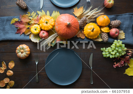 Fall dark place setting with leaves and pumpkins. Fall dark place setting with leaves and pumpkins. 66107958