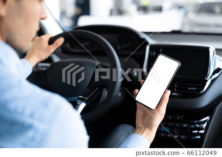 Man Using Smart Phone Sitting In Car In Auto Center Man Using Smart Phone Sitting In Car In Auto Center 66112049