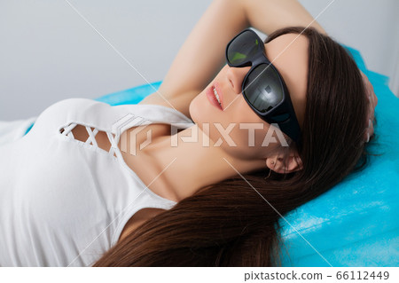 Woman getting laser treatment in a beauty salon 66112449